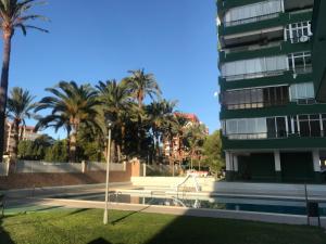 a building with palm trees in front of it at Apartamento residencial Las Palmeras in Benicàssim