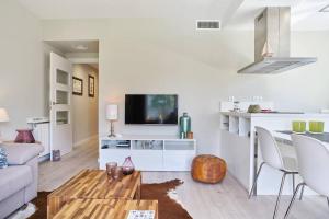 a living room with a couch and a tv at Pure Pool Sensation Apartment Sitges in Sitges