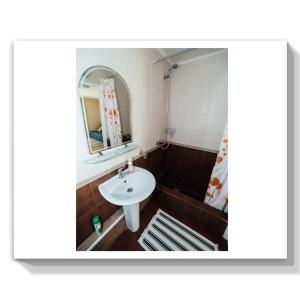 bagno con lavandino e specchio di Guest House Marina a Il'ich