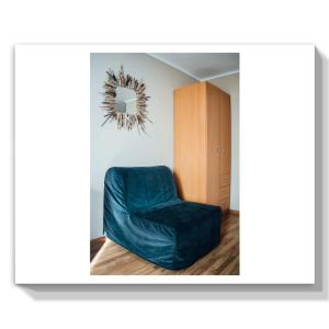 a living room with a blue chair and a mirror at Guest House Marina in Il'ich