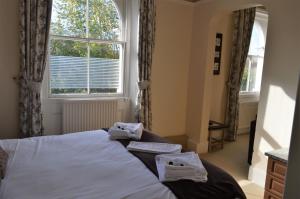 1 dormitorio con 1 cama con toallas en The Sheldon B&B - FREE private parking, en Eastbourne