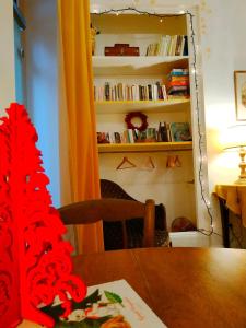 a dining room table with a book shelf with books at Le Voltaire in Souppes-sur-Loing