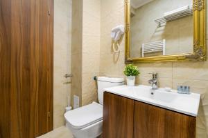 a bathroom with a toilet and a sink and a mirror at BUCUR 9 in Bucharest +49 photos