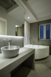 a bathroom with a large sink and a tub at Art Suites Korai in Athens