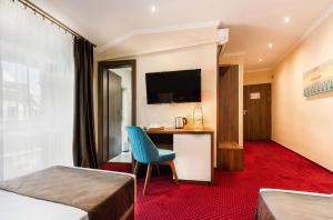 a hotel room with a desk and a television at BUCUR 9 in Bucharest