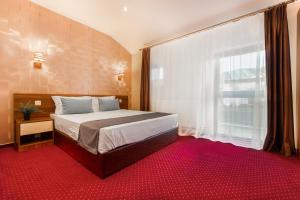 a bedroom with a bed and a large window at BUCUR 9 Boutique Hotel in Bucharest