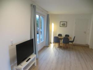 een woonkamer met een televisie en een tafel met stoelen bij City Apartment Amadeus in Salzburg