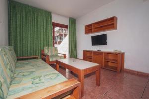 ein Wohnzimmer mit einem Sofa, einem Tisch und einem TV in der Unterkunft Montecarlo Apartamento39 in Puerto Rico de Gran Canaria