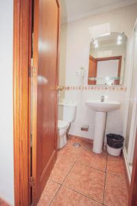 ein Badezimmer mit einem Waschbecken, einem WC und einem Spiegel in der Unterkunft Montecarlo Apartamento39 in Puerto Rico de Gran Canaria