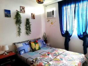 a bedroom with a bed and blue curtains at The Escape Pad 1 by Sharon May in Manila