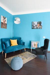 uma sala de estar azul com um sofá azul e uma cadeira em B&B Piccoli Leoni em Gênova