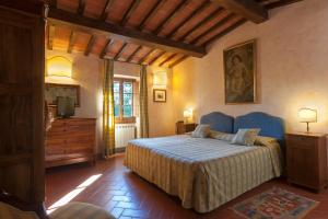 a bedroom with a bed and a dresser at Relais Poggio Borgoni in San Casciano in Val di Pesa