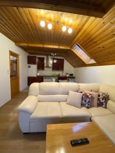 Apartment Bosili في موجسترانا: غرفة معيشة مع أريكة بيضاء وسقف خشبي
