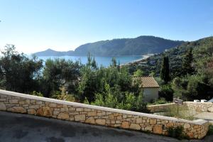a stone wall with a view of a lake at Villa Theodora View Apartments Zeys in Agios Georgios Pagon