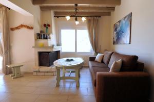 a living room with a couch and a table at Villa Theodora View Apartments Zeys in Agios Georgios Pagon