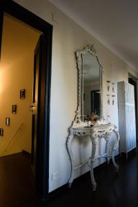 um toucador branco com um espelho na parede em B&B Piccoli Leoni em Gênova