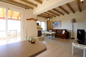 a living room with a couch and a tv at Villa Theodora View Apartments Zeys in Agios Georgios Pagon