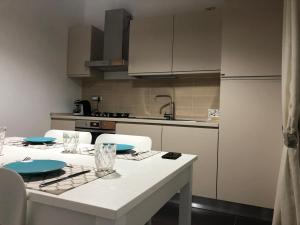 a kitchen with a table with chairs and a refrigerator at RAJA ROOMS in Alife