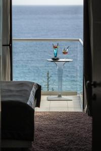 a room with a bed and a table with a view of the ocean at Boutique Hotel Life in Rogoznica