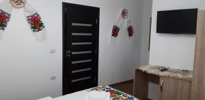 a room with scarves on the wall and a table at Casa MYM in Moisei