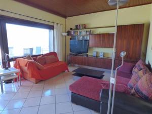 ポルト・ヴァルトラヴァーリアにあるMonte Sole IIのリビングルーム(赤いソファ、テレビ付)