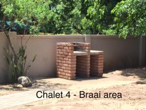 um banco de tijolos em frente a uma cerca em Impala Chalets em Phalaborwa