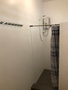 een douche in een badkamer met een gordijn bij The Broken Board in General Luna