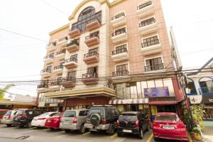 un gran edificio con coches estacionados frente a él en RedDoorz Plus near Johnson and Johnson Paranaque en Manila