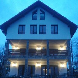 a large white house with lights on it at Popasul din Pietrar in Preluca Veche