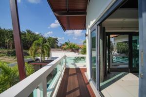 einen offenen Balkon mit Blick auf ein Haus in der Unterkunft Resona Pool Villa by Aonanta Group in Ao Nam Mao