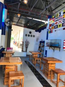 a restaurant with wooden tables and benches in a room at ANCHORAGE INN Moalboal in Moalboal