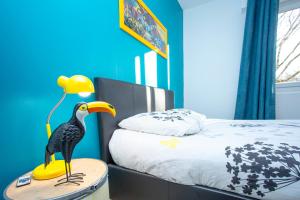 ロリアンにあるSMILE APPARTS - Appartements - Au coeur de Lorient - Au calme - Tout Confortのベッドルーム1室(ベッドの横のテーブルに鳥のおもちゃ付)