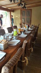 a long wooden table with wicker chairs in a room at B & B Teranga Warang in Ouoran