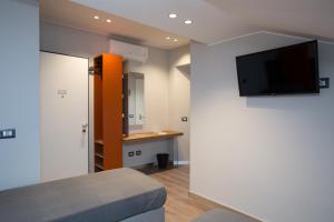 a room with a bed and a tv on a wall at Etna Sunrise b&b in Zafferana Etnea