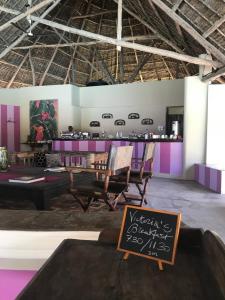 un restaurante con una mesa y un cartel en una habitación en The Lawford, en Malindi