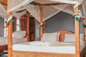 1 Schlafzimmer mit 2 Betten mit Baldachin und weißen Kissen in der Unterkunft Mabata Makali Luxury Tented Camp in Ruaha National Park