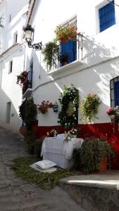 a white building with flowers on the side of it at Guesthouse La Tienda Cómpeta 21b in Cómpeta