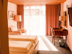 a hotel room with two beds and a desk at Hillsite Smart Hotel Flims in Flims