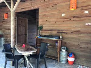 un patio con mesa y sillas en una pared de madera en Soul Fire Casitas, en Montezuma