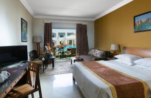 a hotel room with a bed and a living room at Xperience St. George Sharm El Sheikh in Sharm El Sheikh