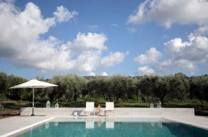 - une piscine avec des chaises et un parasol dans l'établissement Gallo Fino, à Ricadi