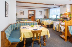 een eetkamer met tafels en stoelen en een eettafel bij OLYMPIA Privathotel Garni in Sankt Jakob in Defereggen