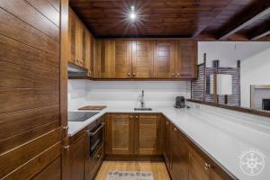 - une cuisine avec des placards en bois et un évier dans l'établissement LOS CIERVOS de Alma de Nieve, à Baqueira-Beret