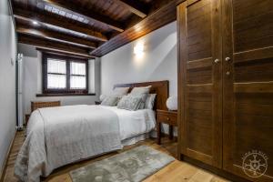 1 dormitorio con 1 cama y pared de madera en LOS CIERVOS de Alma de Nieve en Baqueira Beret