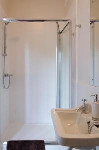 biała łazienka z prysznicem i umywalką w obiekcie The Lions w mieście Newark-on-Trent