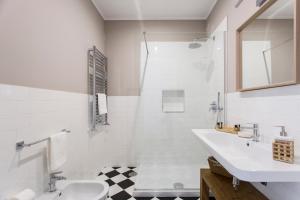 bagno bianco con lavandino e doccia di Dimora Toledo a Napoli