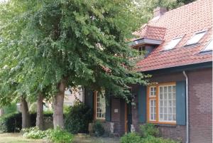 a house with a red roof and trees at B&B Bij Bijnen in Soerendonk