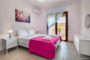 a bedroom with a bed with a pink blanket at Villa Oliva in Astris