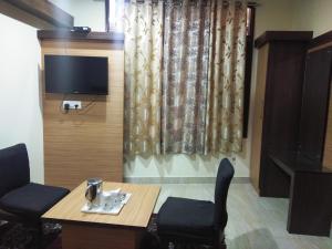 达兰萨拉Hotel Nature's View的有桌椅和电视的房间