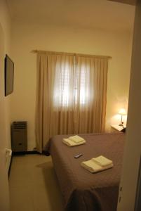 a bedroom with a bed with two towels on it at Sur Hotel in Necochea